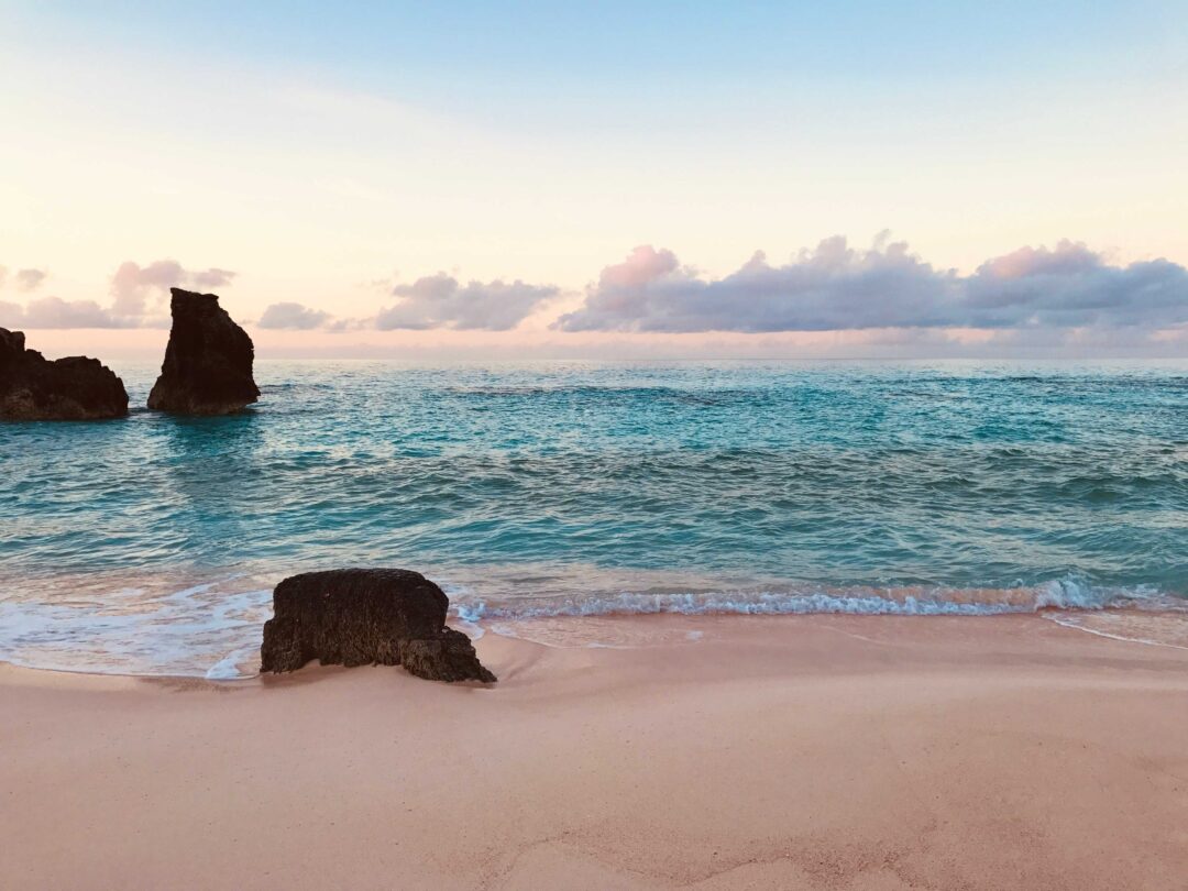 Foto di un spiaggia delle bermuda al tramonto, con mare azzurro e sabbia dorata